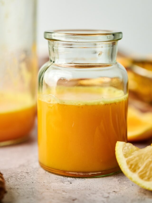 A ginger turmeric shot in a large glass.
