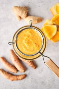Ginger turmeric shot pulp in a mesh sieve.