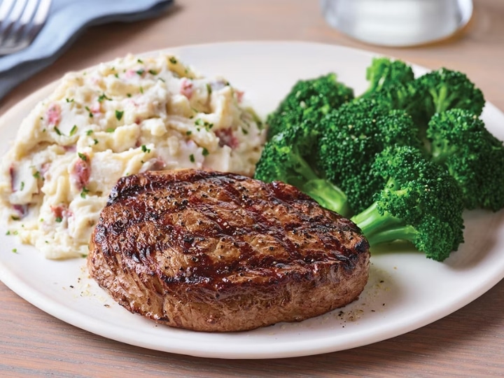 Sirloin steak on a plate with mashed potatoes and broccoli.