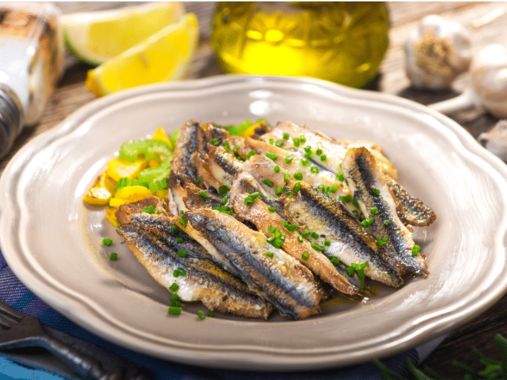 A bunch of anchovies in a plate.