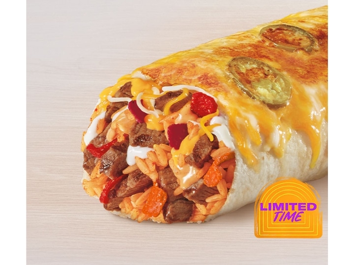 Steak and cheese in a grilled burrito covered in cheese.