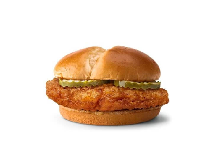 A crispy chicken sandwich with pickles on a bun. 