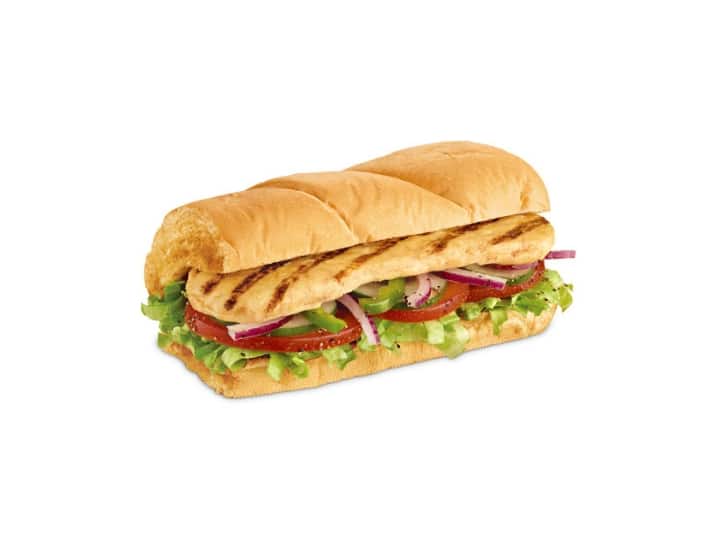 A sub with oven roasted chicken breast, tomato, lettuce, onion, and green pepper.