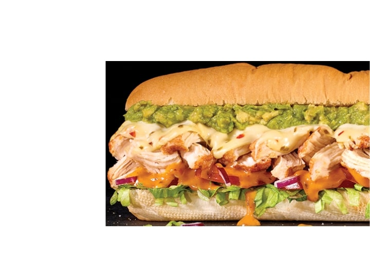 A sub with guac, pepper jack cheese, bacon, chicken, lettuce, and red onion.