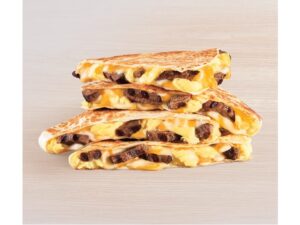 Steak, eggs, and cheese quesadilla triangles on top of one another.