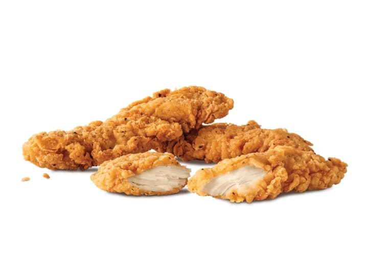 Two chicken tenders and one chicken tender broken in half.