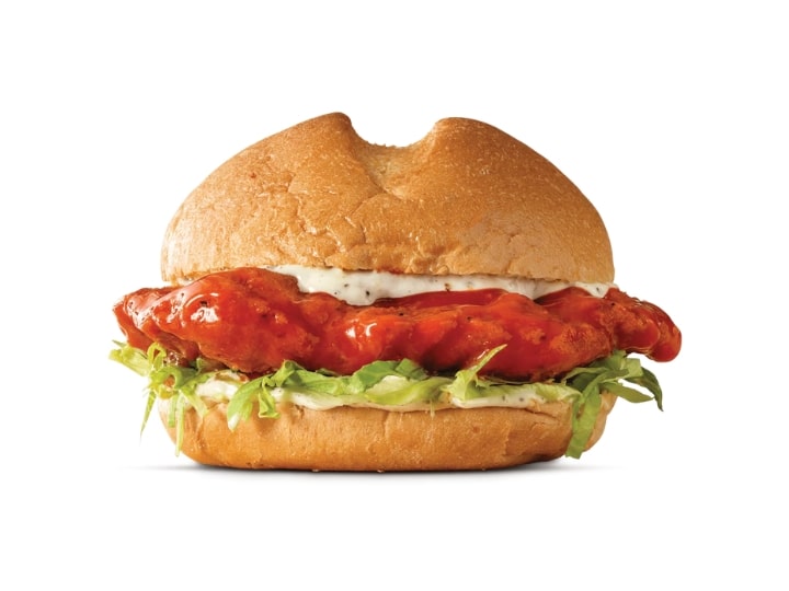 A bun with buffalo chicken, ranch, and lettuce between it.