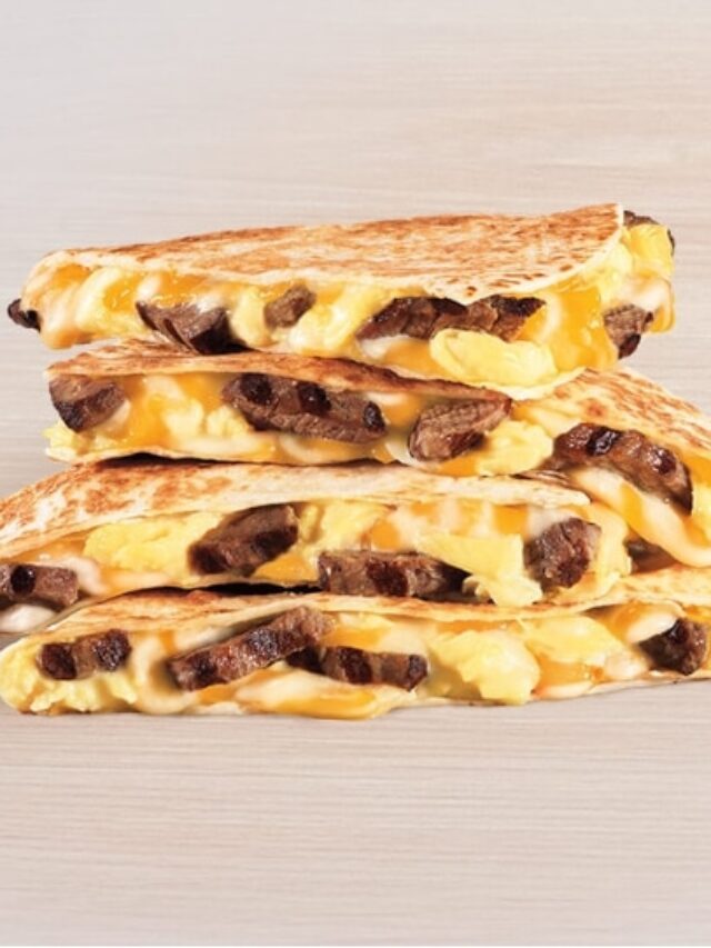 Steak, eggs, and cheese quesadilla triangles on top of one another.