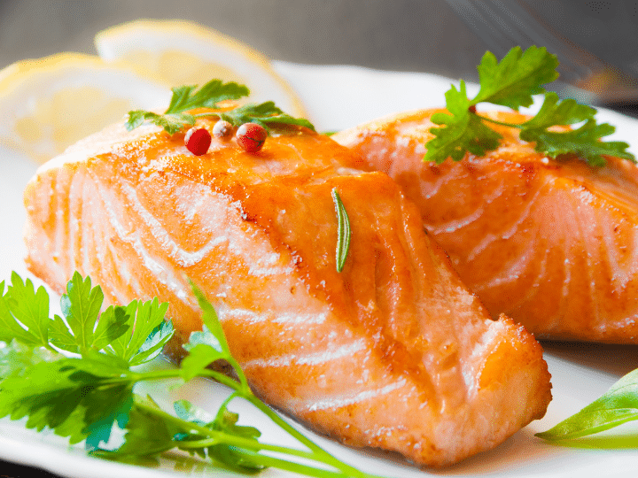 A piece of cooked salmon on a white plate.