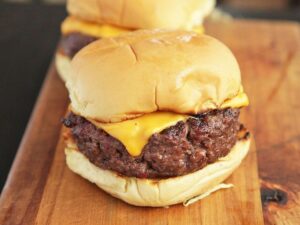 A bison burger with American cheese on a bun.