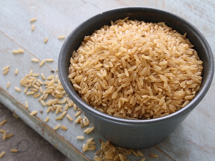 A bowl of brown rice on a grey counter.