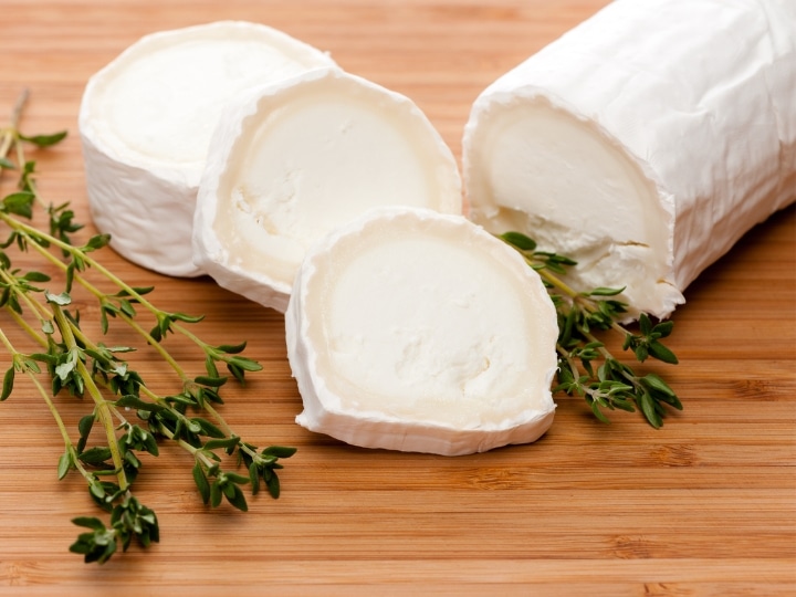 Three slices of goat cheese with a part of a block of goat cheese behind it.