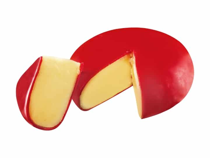 A red wheel of gouda cheese with a slice out of it.