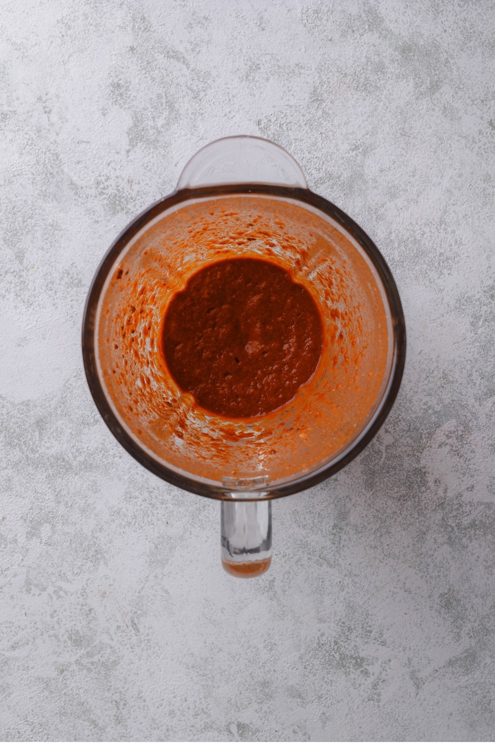 An overhead shot of a glass blender with a mixed al pastor marinade.