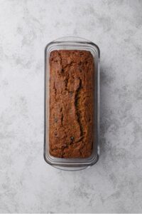 A glass loaf pan with a baked zucchini bread loaf.