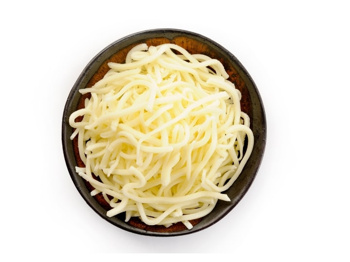 Shredded mozzarella cheese in a wooden bowl.