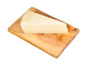 A triangle block of pecorino romano cheese on a wooden cutting board.