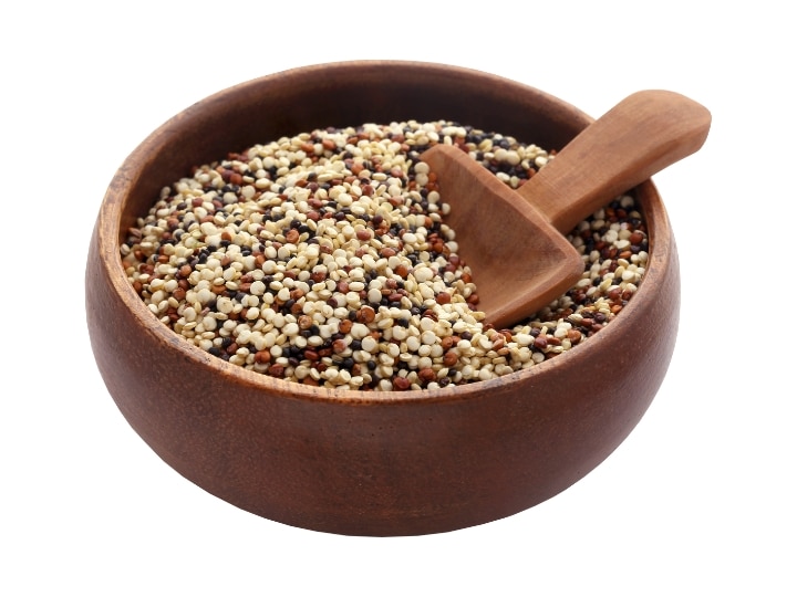 A bowl of quinoa with a wooden spoon in it.
