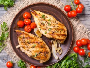 Two pieces of grilled chicken on a plate.