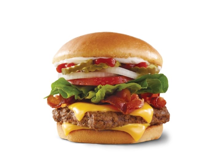 A cheeseburger with bacon, lettuce, onion, tomato, ketchup and mayo.