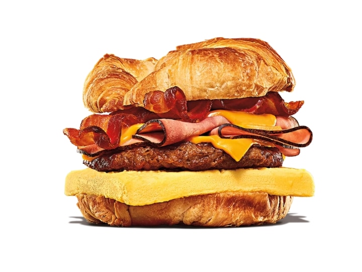 A croissant with bacon, ham, sausage, egg, and cheese.