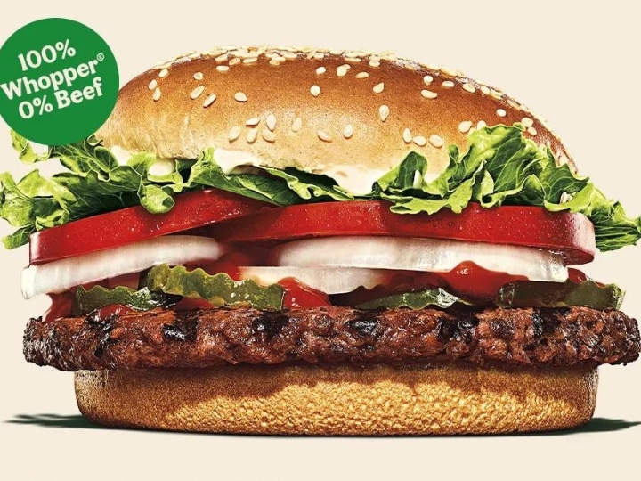 A veggie burger with lettuce, tomato, onion, ketchup and pickles.
