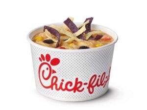 A chick fil a white bowl with chicken tortilla soup in it.