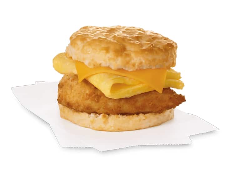 A biscuit with cheese, an egg, and breaded chicken.