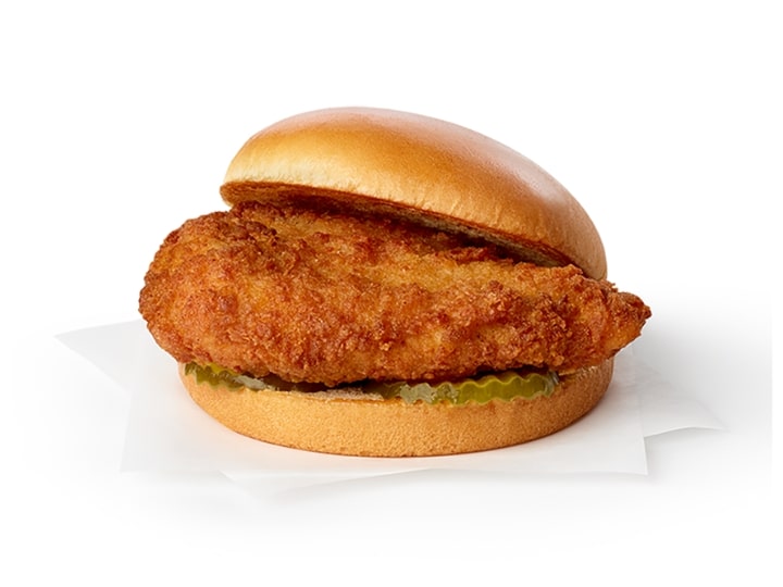 A breaded chicken sandwich with pickles.