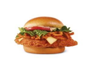 A spicy chicken sandwich with onion rings, lettuce, and tomato.