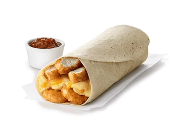 A wrap with eggs, hashbrowns, and chicken nuggets.