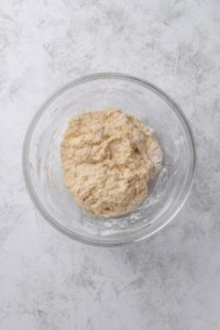 An overhead shot of a glass bowl with oatmeal dough