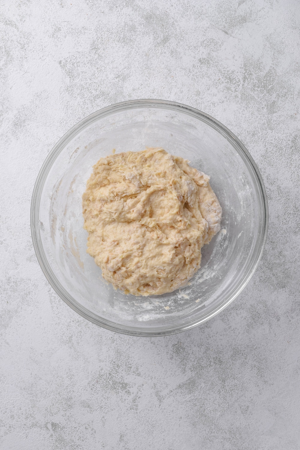 An overhead shot of a glass bowl with oatmeal dough