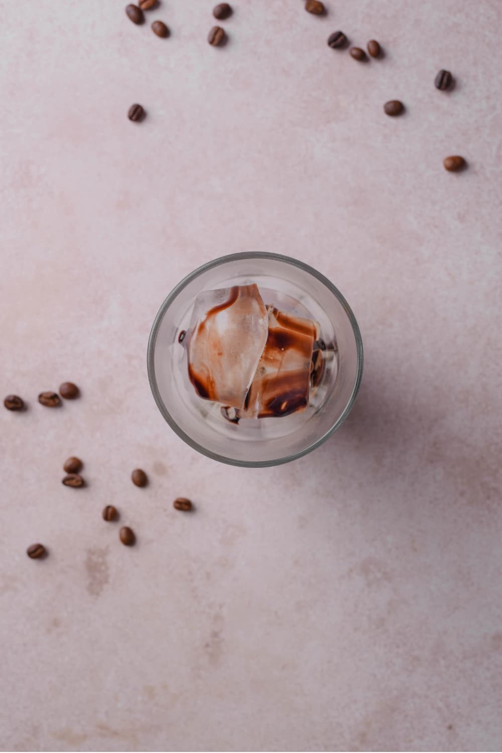An overhead shot of a glass filled with ice drizzled with chocolate sauce