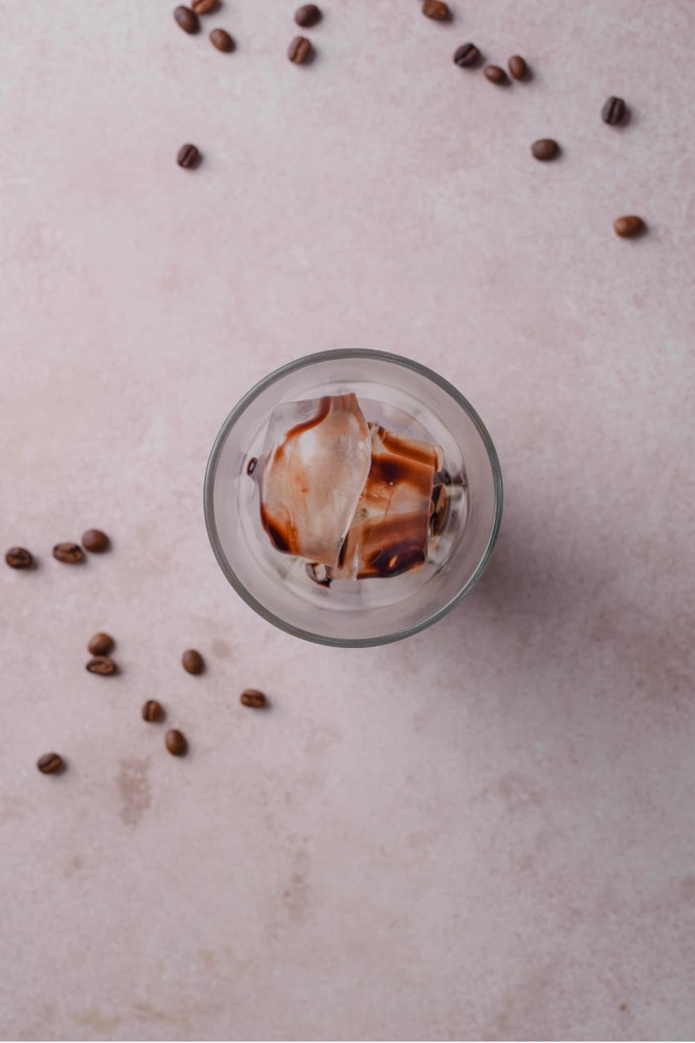 An overhead shot of a glass filled with ice drizzled with chocolate sauce