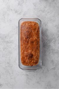 An overhead shot of baked oat bread in a loaf pan.
