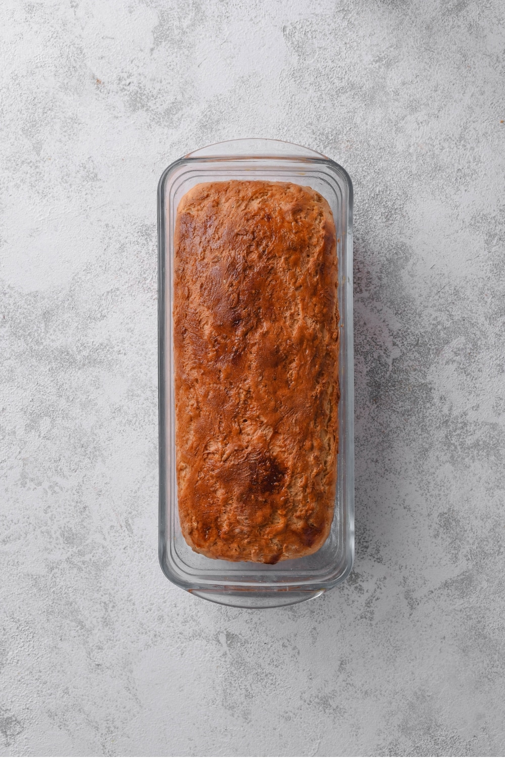 An overhead shot of baked oat bread in a loaf pan.