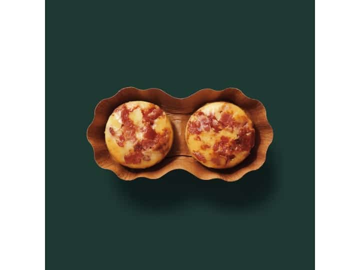 Two bacon gruyere egg bites in a brown paper.