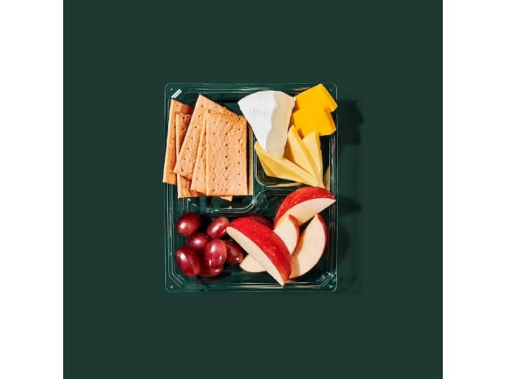 A box with grapes, apples, three kinds of cheese, and crackers.