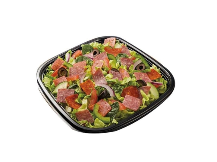 Sliced salami and on top of mixed greens with sliced onion.