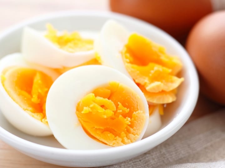 Four hard boiled eggs on a white plate.