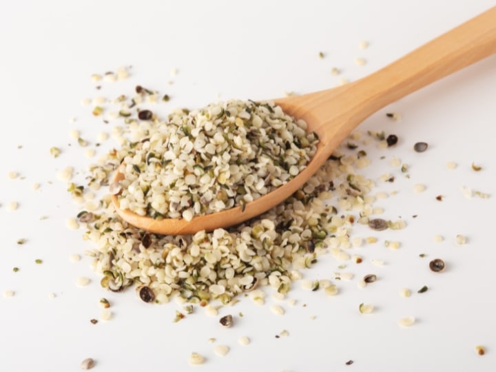 A bunch of hemp seeds on a wooden spoon.