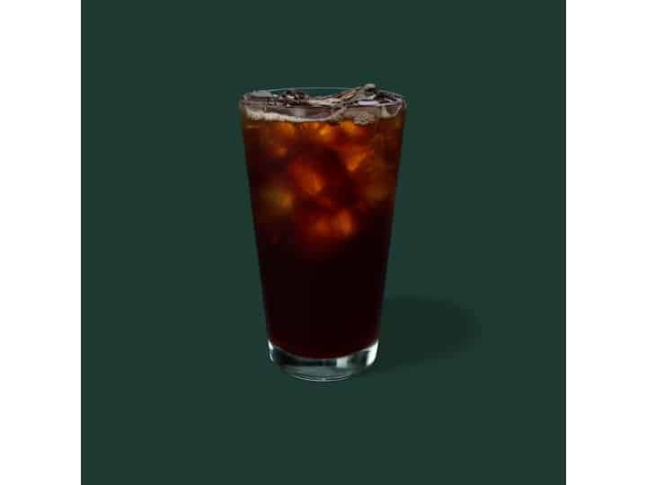 A clear glass of starbucks decafe coffee.