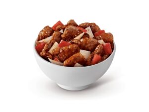 A bowl of beijing beef and red bell peppers.