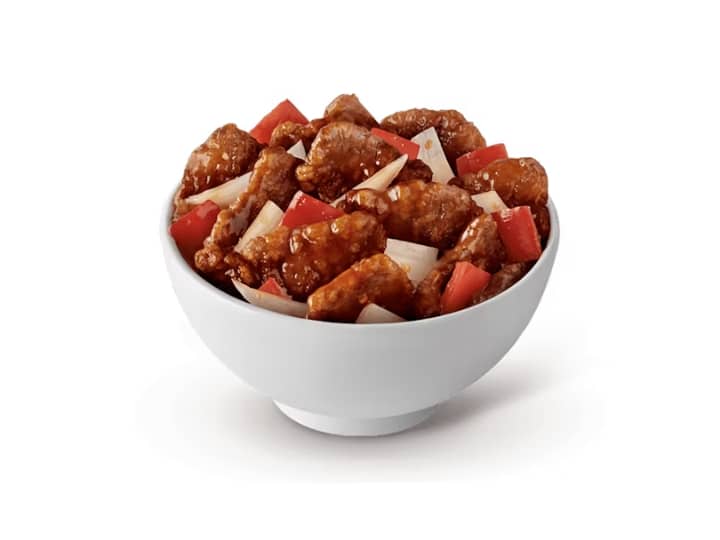 A bowl of beijing beef and red bell peppers.