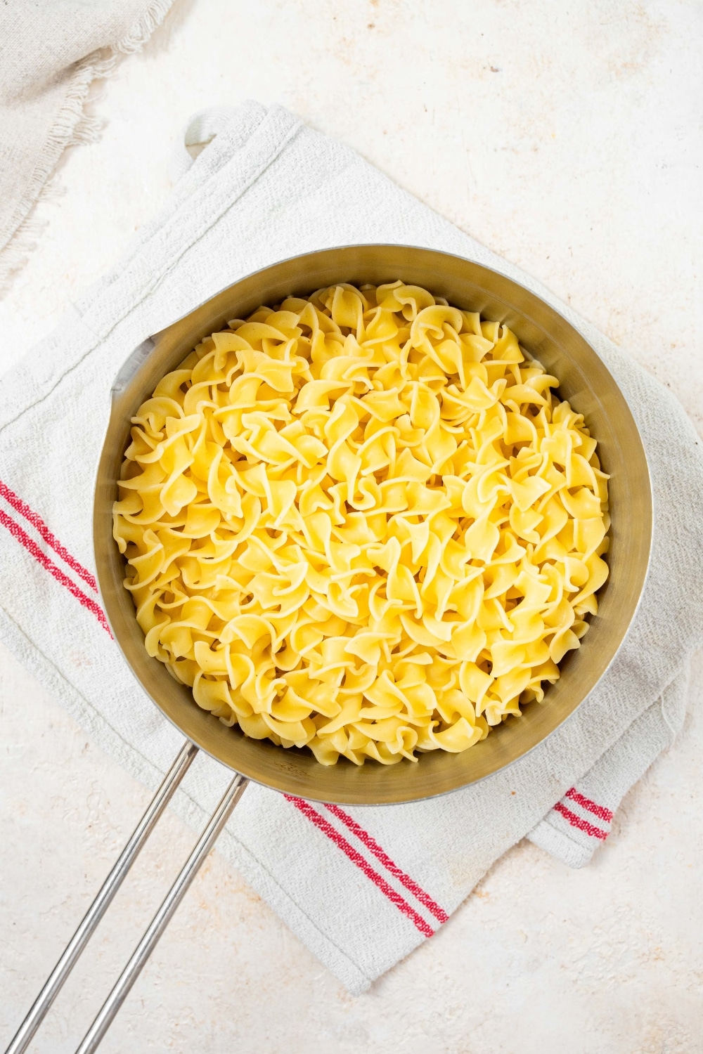 An overhead shot of a pot filled with cooked egg noodles.