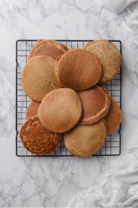 An overhead shot of several cooked high fiber pancakes cooling on a wire rack.