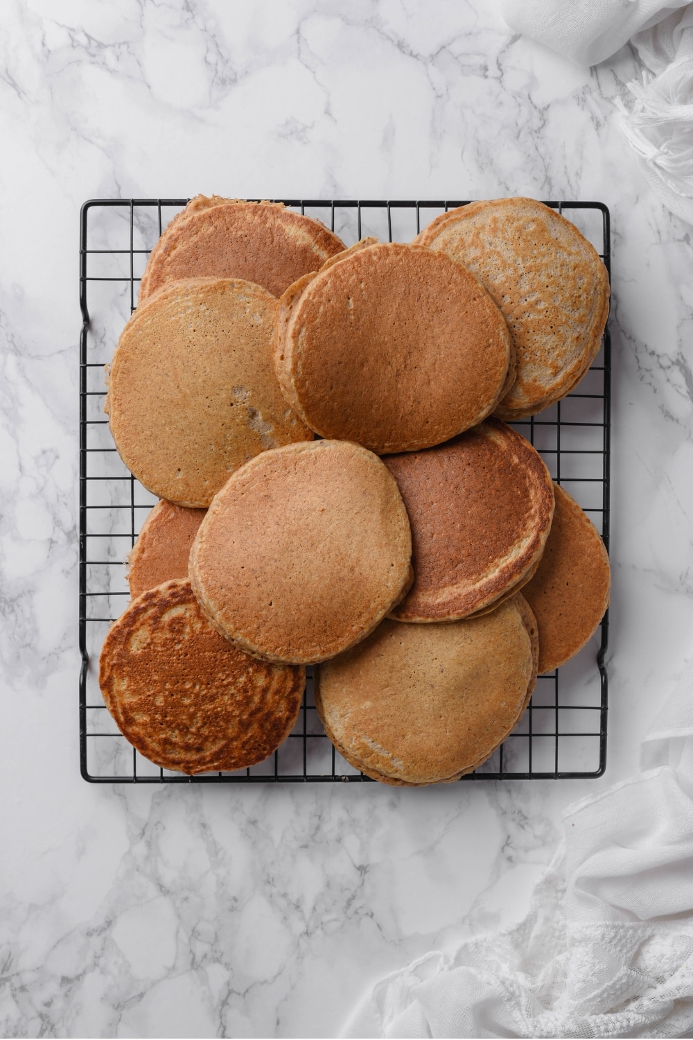 An overhead shot of several cooked high fiber pancakes cooling on a wire rack.