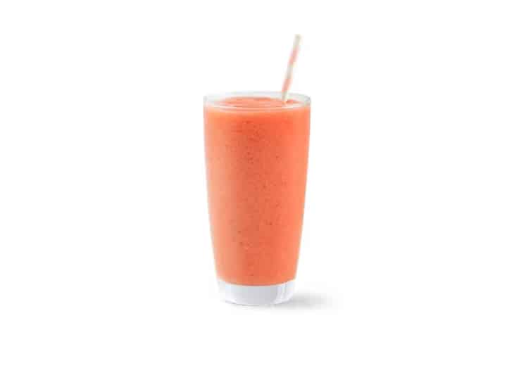 A glass cup filled with a pink smoothie.