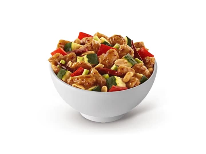 A bowl of kung pao chicken and veggies.